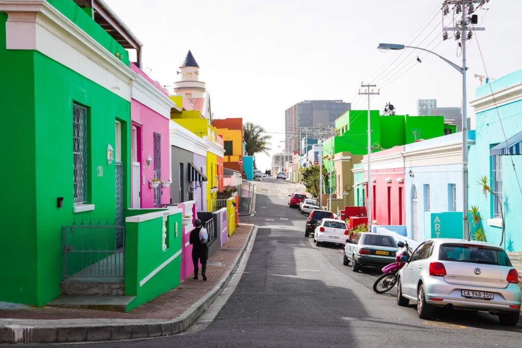 cars parked beside green and white concrete building during daytime